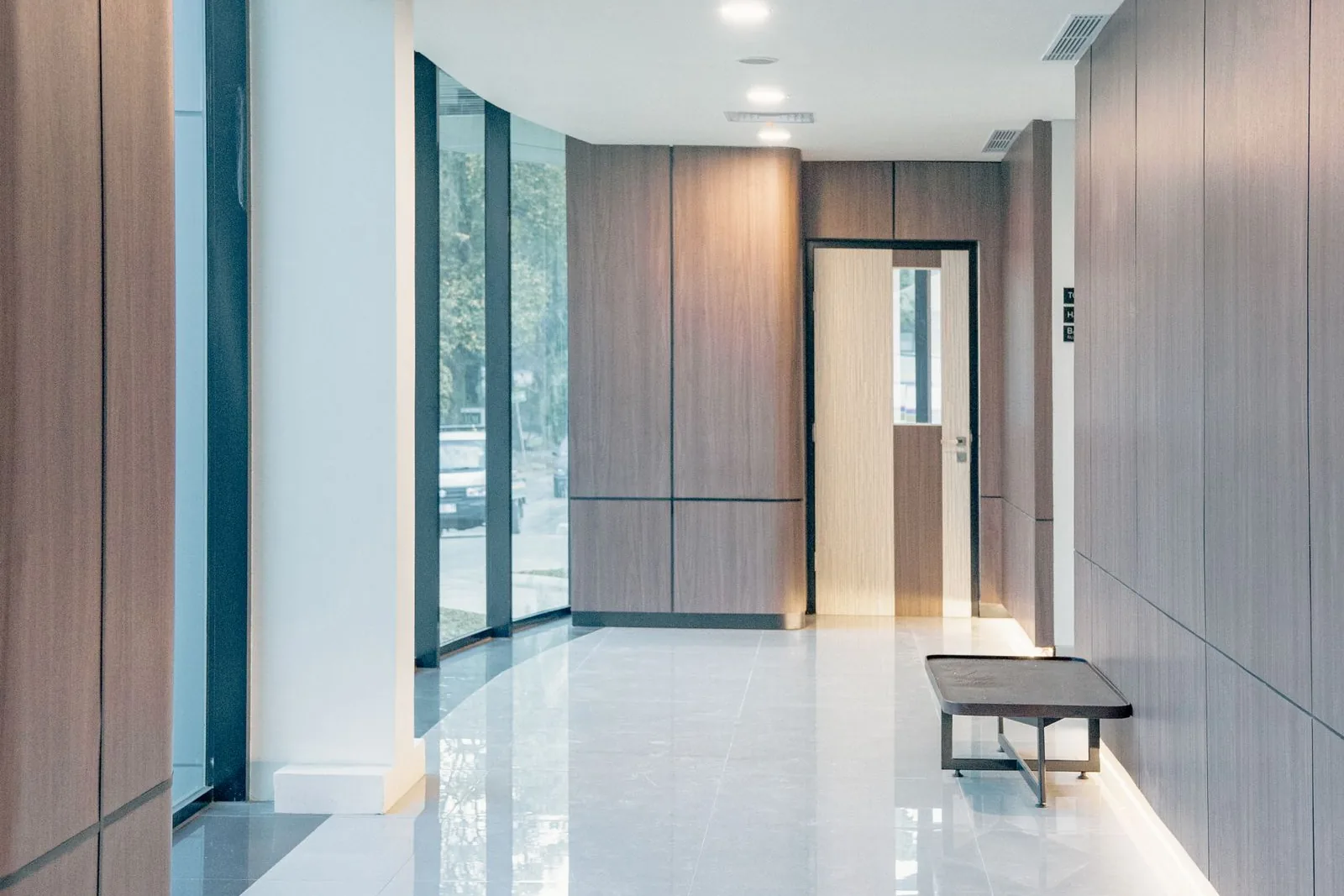 A minimal, architectural clinic reception with wood-panelled walls and soft natural light