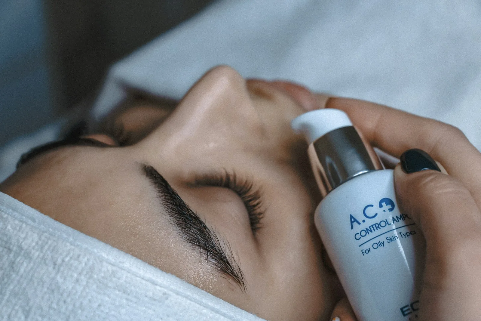 A clinical serum applied during a calm, elegant facial treatment