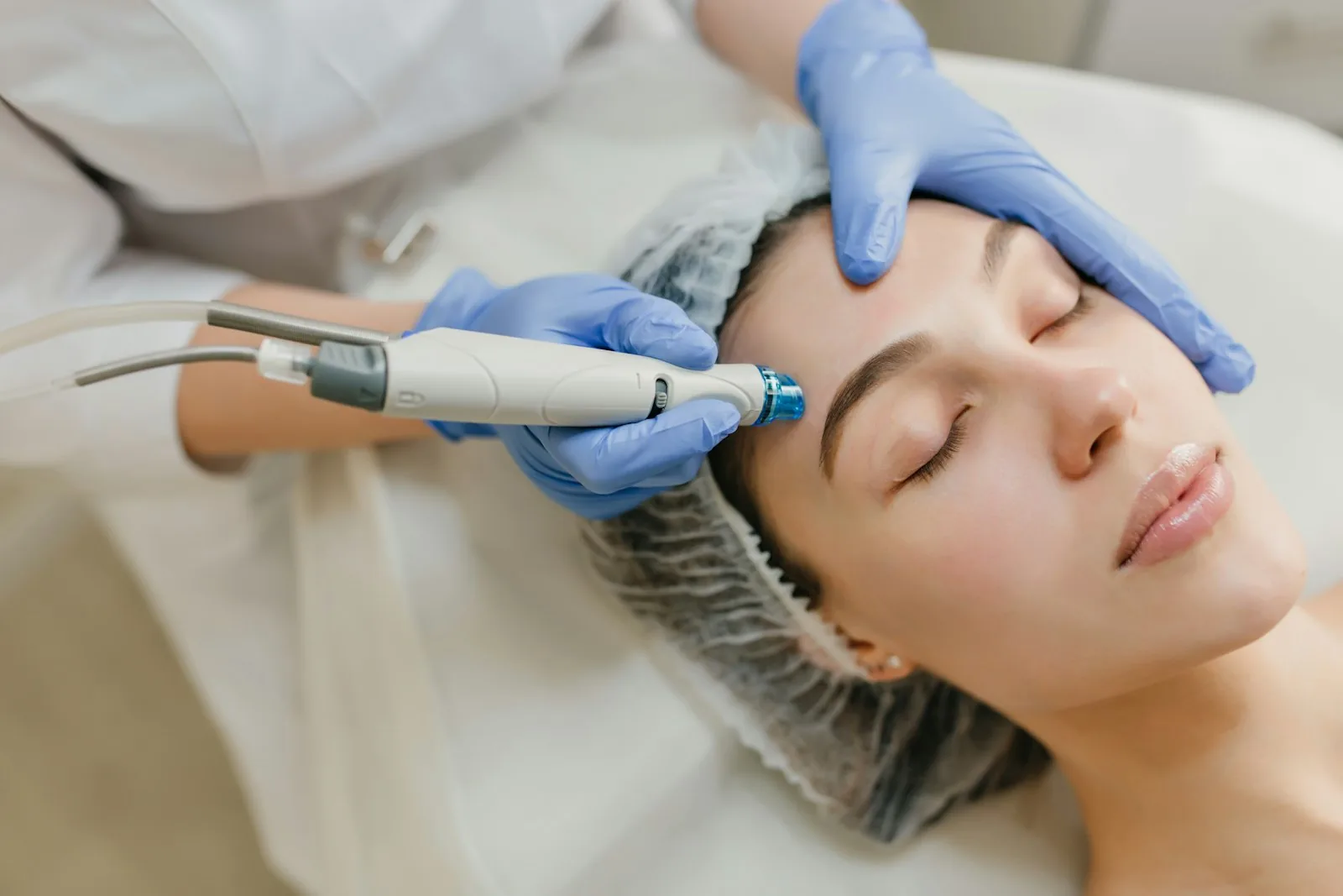 A practitioner using a non-surgical skin device during a facial treatment